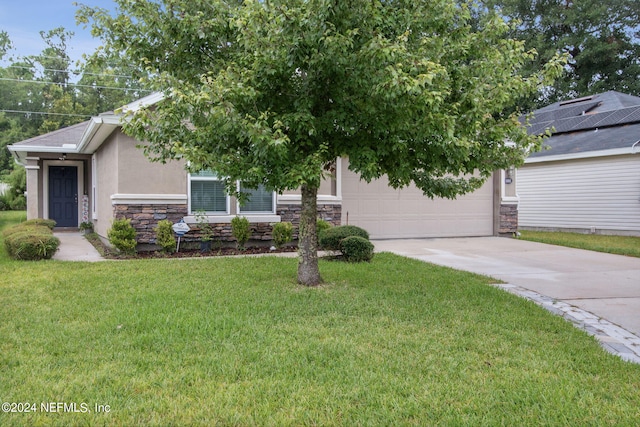 view of property hidden behind natural elements with a garage and a front lawn