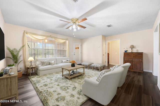 living room featuring dark wood-type flooring and ceiling fan