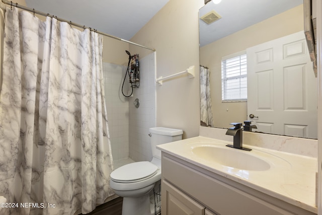 bathroom featuring vanity, toilet, and walk in shower