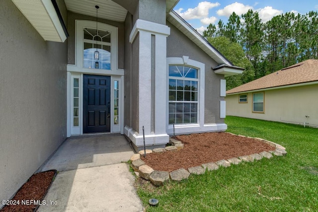 property entrance featuring a lawn