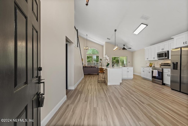 kitchen featuring white cabinets, light hardwood / wood-style flooring, stainless steel appliances, ceiling fan, and a kitchen island