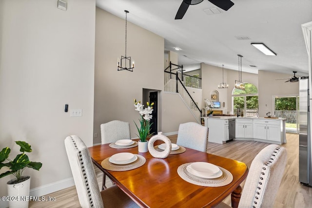 dining space featuring high vaulted ceiling, ceiling fan, and light hardwood / wood-style flooring