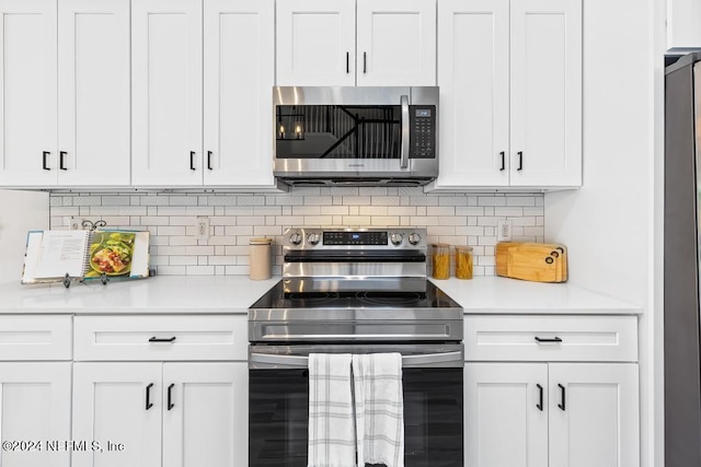 kitchen featuring appliances with stainless steel finishes, white cabinetry, and backsplash