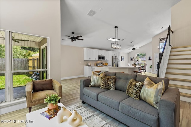 living room featuring light wood-type flooring, vaulted ceiling, and ceiling fan