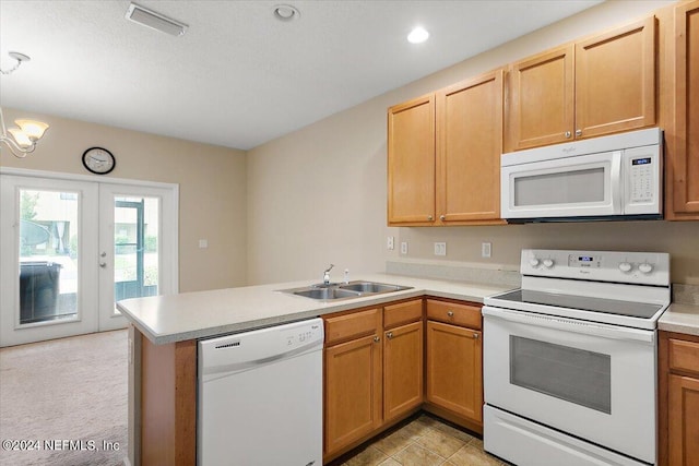 kitchen with white appliances, visible vents, a peninsula, a sink, and light countertops