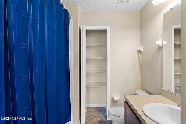 full bathroom with curtained shower, a textured ceiling, vanity, and toilet