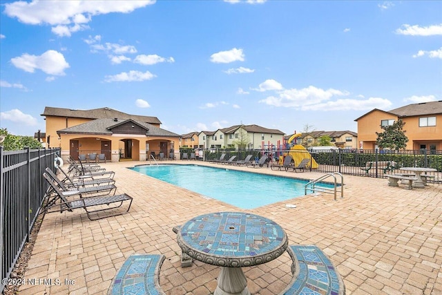 community pool featuring a patio and fence