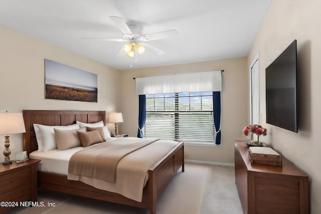 bedroom with light colored carpet, baseboards, and ceiling fan