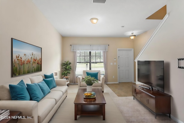 living area featuring baseboards and light carpet