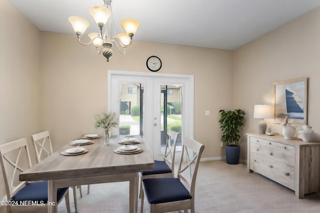 dining space with french doors, baseboards, an inviting chandelier, and light wood-style flooring