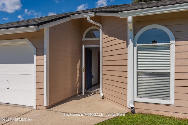 view of exterior entry with a garage