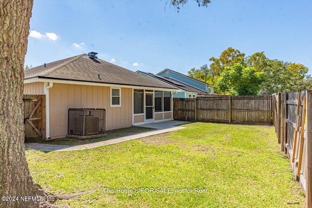 back of property featuring cooling unit and a lawn