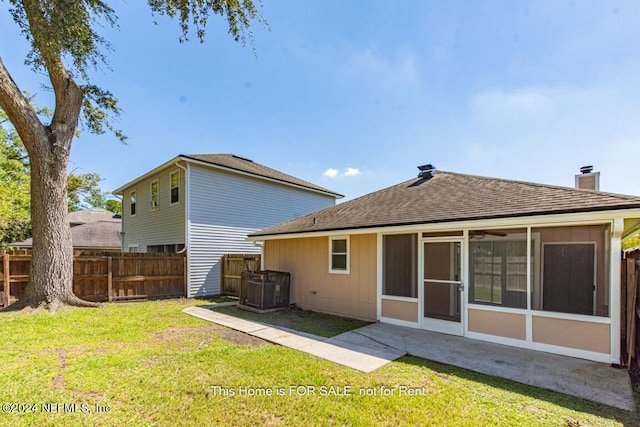 back of property featuring a lawn and a sunroom