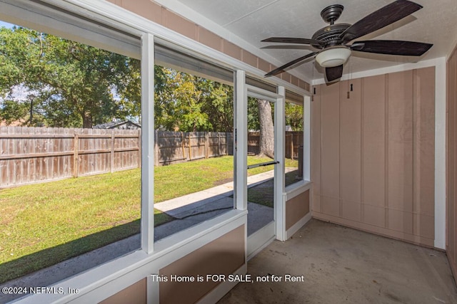 unfurnished sunroom featuring ceiling fan