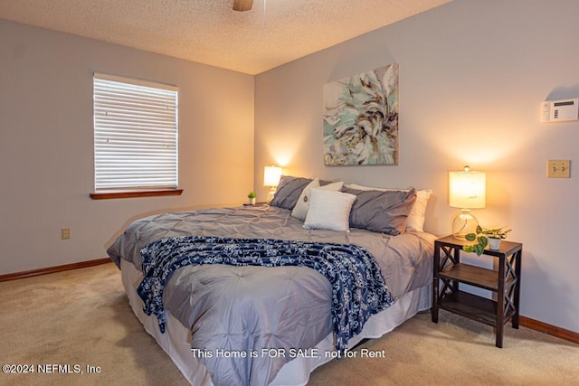 carpeted bedroom with a textured ceiling and ceiling fan