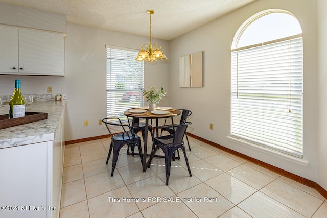 tiled dining room featuring a chandelier and a textured ceiling