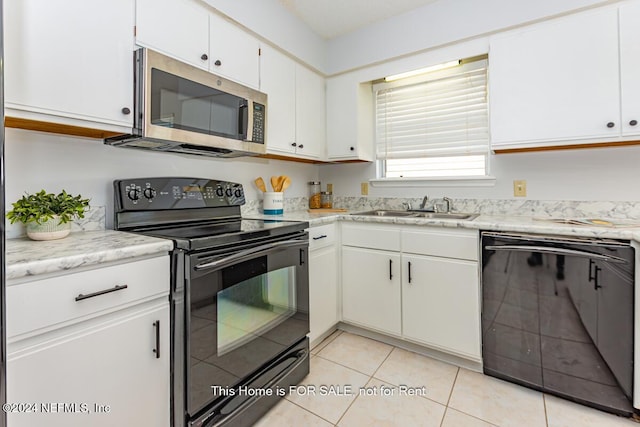 kitchen with light tile patterned flooring, sink, white cabinetry, and black appliances