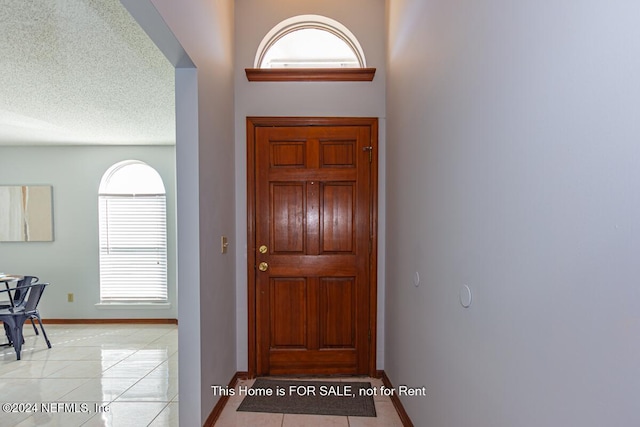 tiled entrance foyer with a textured ceiling and a wealth of natural light