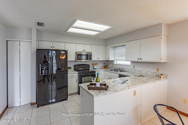 kitchen featuring sink, white cabinetry, black appliances, a textured ceiling, and kitchen peninsula