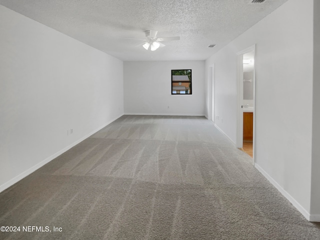 carpeted empty room with a textured ceiling and ceiling fan