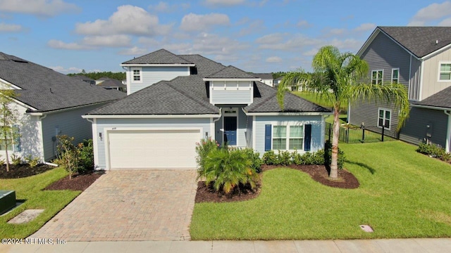 view of property with a garage and a front lawn