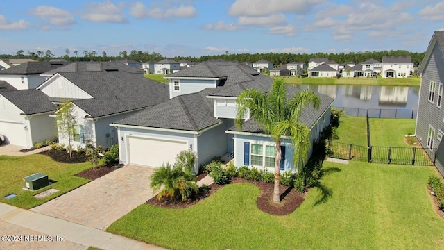 view of front of property featuring a water view, a front lawn, and a garage