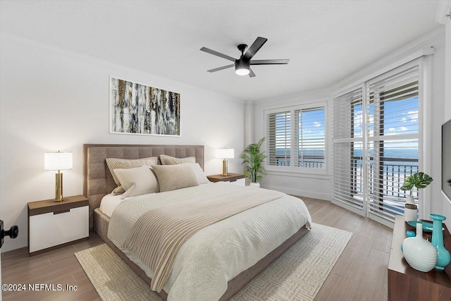 bedroom featuring ornamental molding, wood-type flooring, and ceiling fan