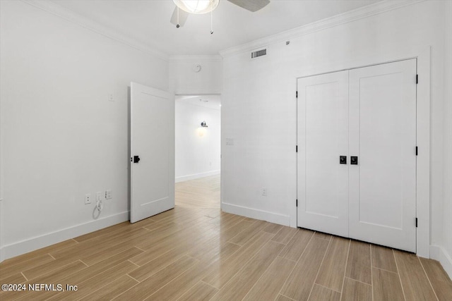 unfurnished bedroom with ceiling fan, ornamental molding, a closet, and light hardwood / wood-style floors