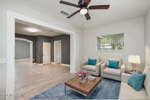 living room with hardwood / wood-style floors, ceiling fan, and crown molding