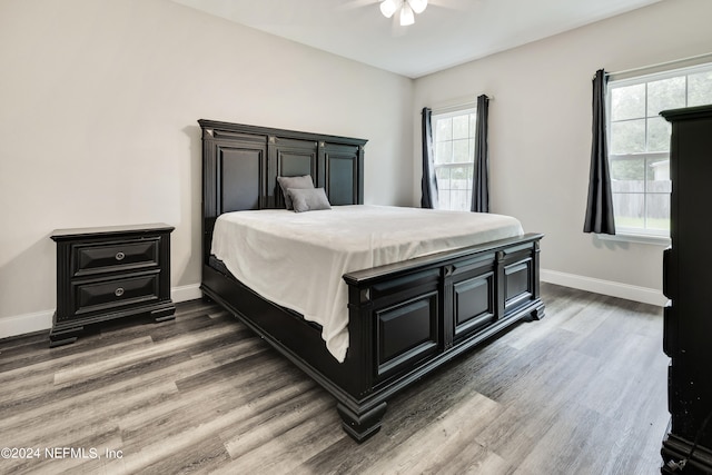 bedroom featuring multiple windows, ceiling fan, and hardwood / wood-style flooring