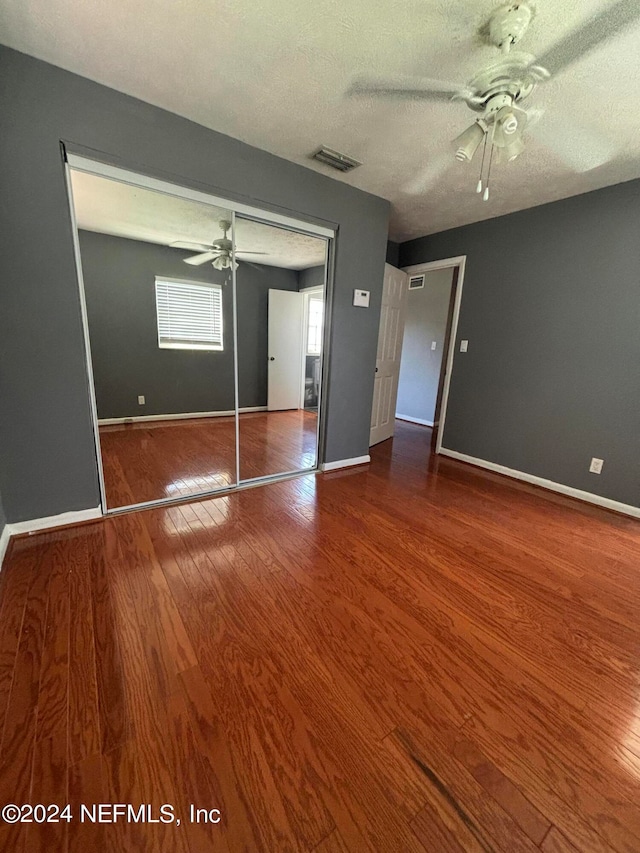 spare room with a textured ceiling, wood-type flooring, and ceiling fan