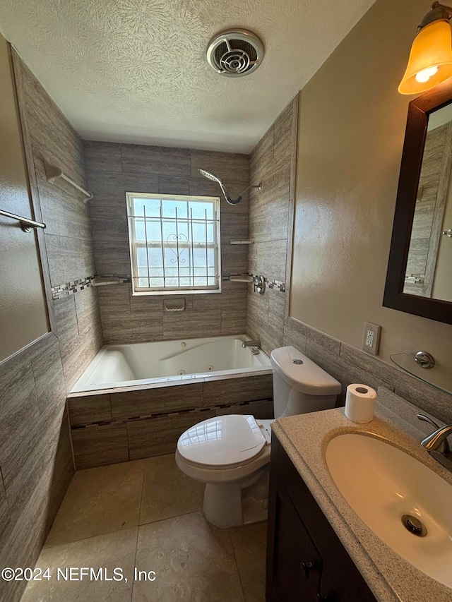 full bathroom with tile walls, vanity, tiled shower / bath, and toilet