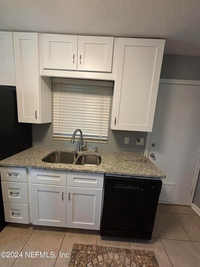 kitchen with light tile patterned floors, sink, a textured ceiling, white cabinetry, and dishwasher