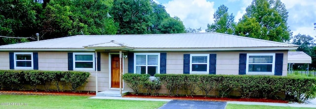 ranch-style house featuring metal roof, a front yard, and entry steps