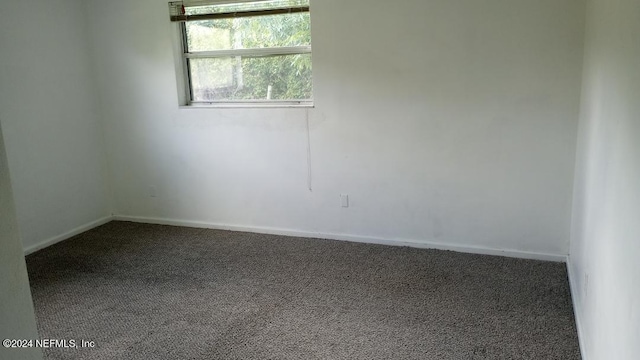 carpeted spare room with baseboards
