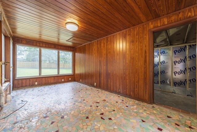 empty room with wood ceiling and wooden walls