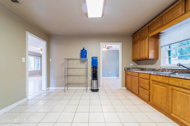 kitchen with ornamental molding, ceiling fan, sink, and light tile patterned floors