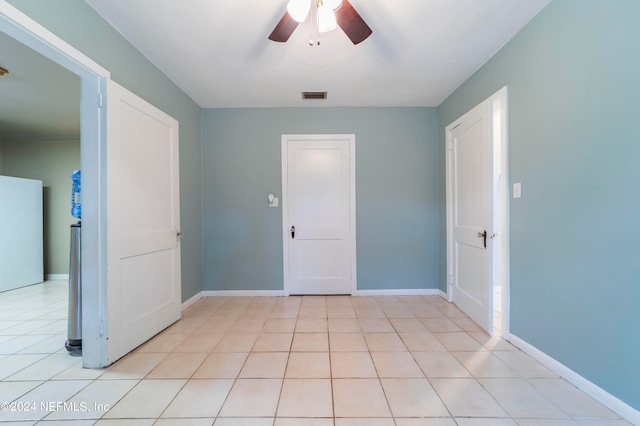 spare room with ceiling fan and light tile patterned floors