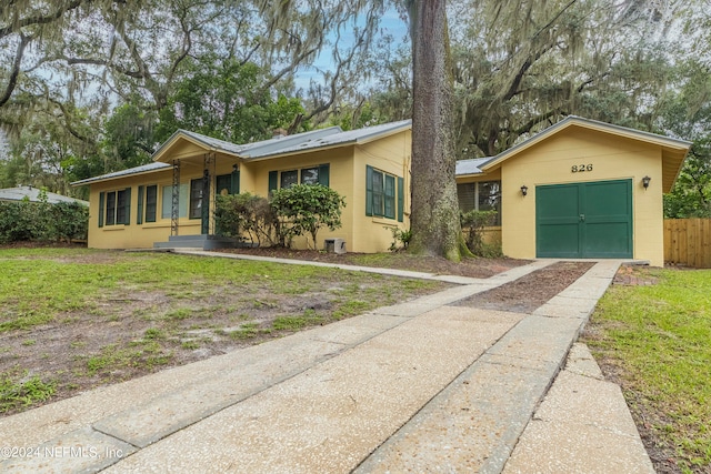 single story home with a front yard and a garage