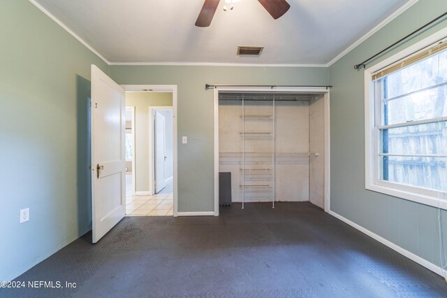 unfurnished bedroom with crown molding, ceiling fan, a closet, and multiple windows