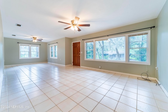 tiled empty room with plenty of natural light and ceiling fan