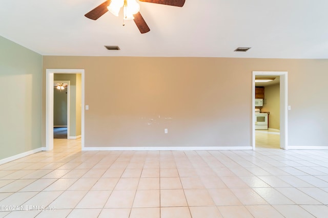 tiled spare room with ceiling fan