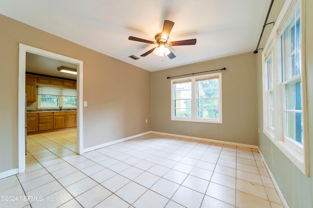 tiled empty room with sink and ceiling fan