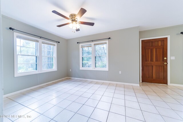 spare room with crown molding, light tile patterned floors, and ceiling fan