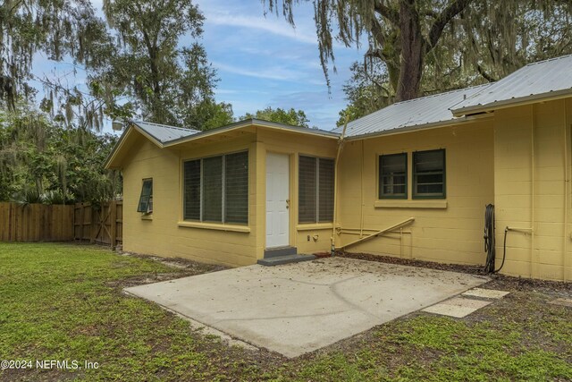 back of house with a yard and a patio