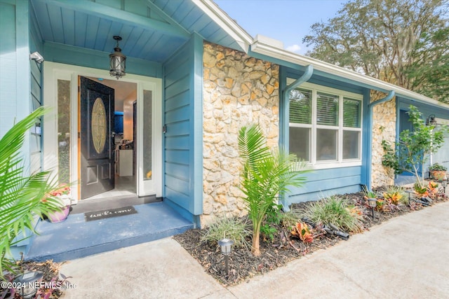 view of exterior entry featuring covered porch