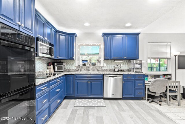 kitchen with black appliances, plenty of natural light, and blue cabinets