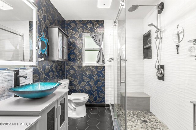 bathroom featuring vanity, toilet, a shower with shower door, and tile patterned flooring