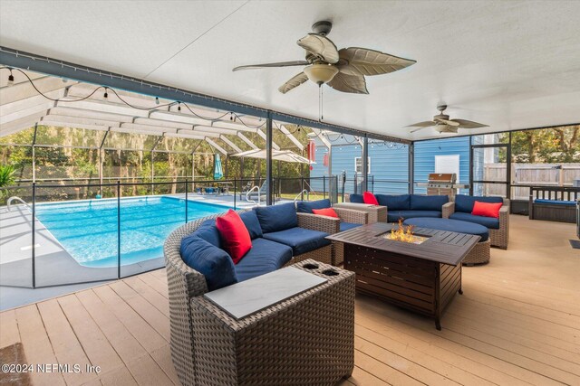 view of swimming pool featuring a wooden deck, ceiling fan, a lanai, and an outdoor hangout area