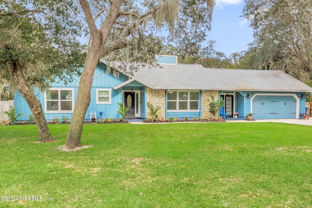 view of front of home with a front yard and a garage